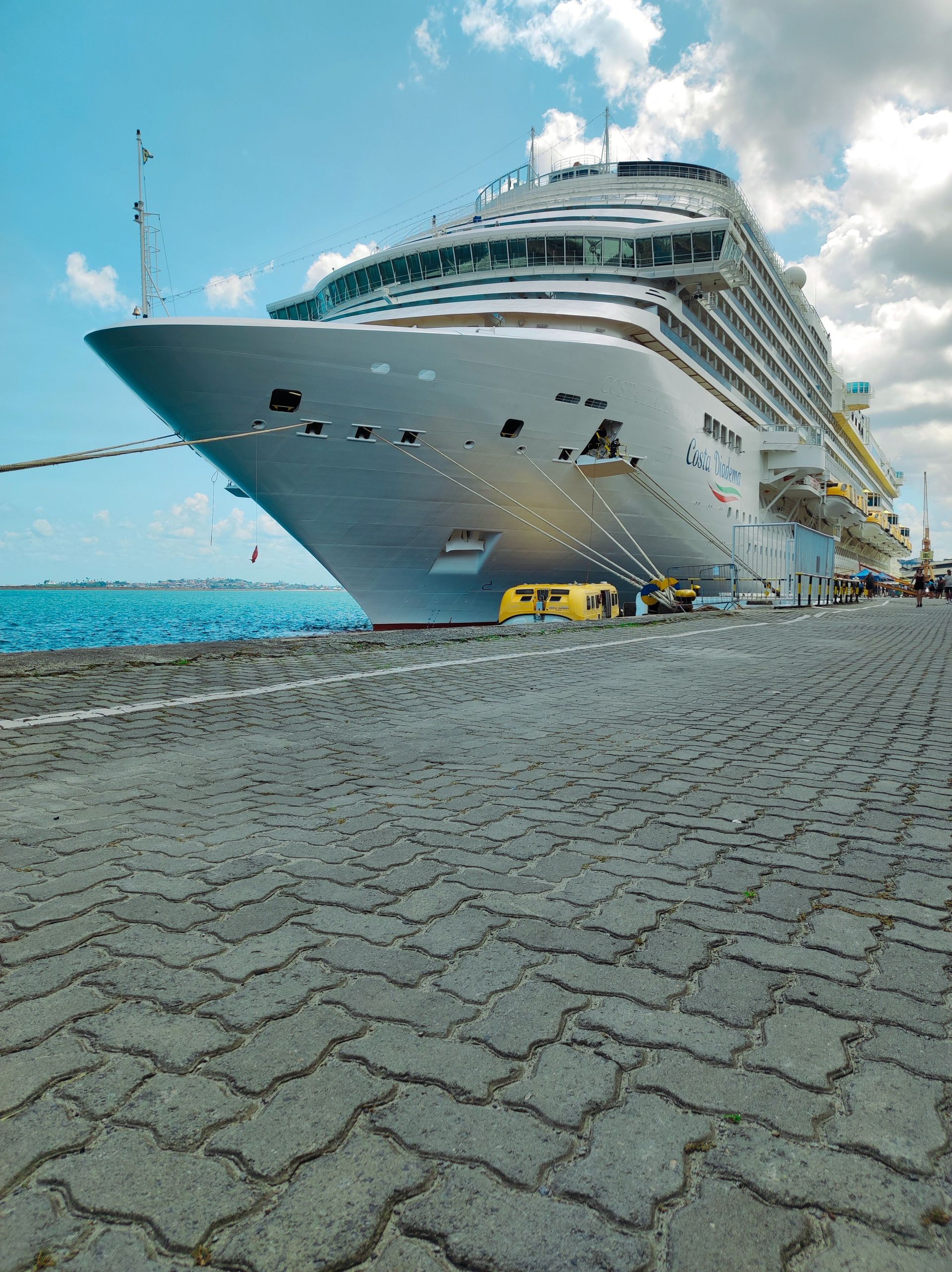 A luxury cruise ship docked at a sunny port, showcasing its grandeur and modern design.